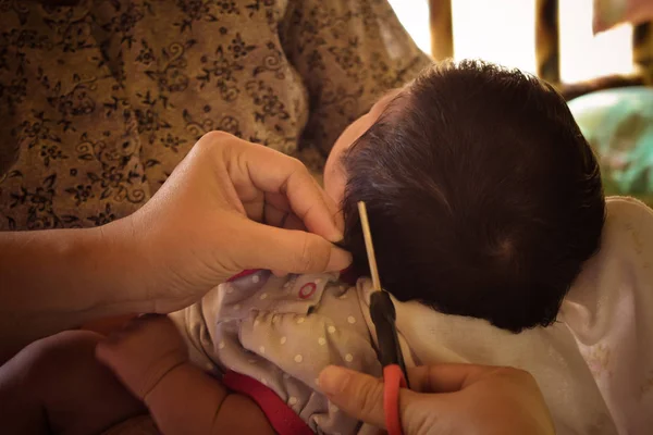Cabelo cortado bebê por tesoura pela primeira vez — Fotografia de Stock