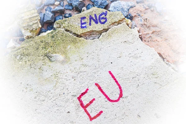 Brexit UK EU referendum concept with word UN and Eng and vote on hand on stone wall