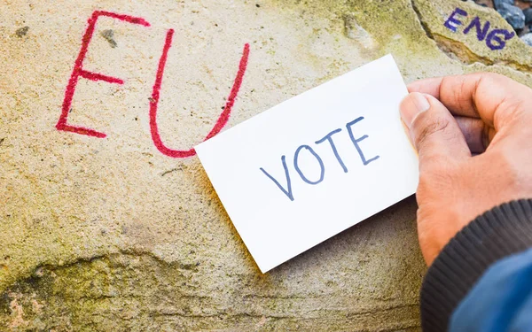Brexit Britse Eu-referendum concept met word VN en Eng en stemming over hand op stenen muur — Stockfoto