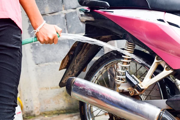 Девушка чистка и стирка розовый мотоцикл — стоковое фото