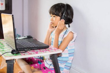 dizüstü bilgisayar kullanan bir küçük kız