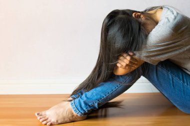 Beyaz arka plan üzerinde oturan üzgün kız