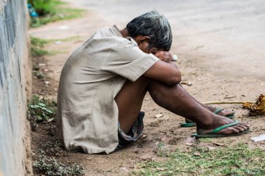 bir sokakta oturan evsiz adam