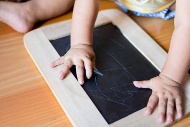 Bebek tebeşir ve yazı tahtası ile karikatür çizmek