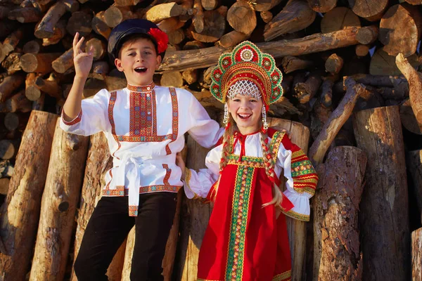 Deux enfants russes en costume folklorique russe garçon et fille dansant ensemble et souriant émotionnellement — Photo
