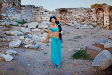 Çekici kız dans, gülümseyen antik kalıntılar arka plan üzerinde Arapça oryantal kostüm