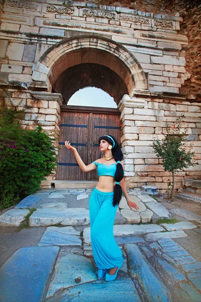 Çekici kız dans, gülümseyen antik kalıntılar arka plan üzerinde Arapça oryantal kostüm