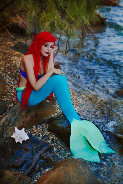 Beautiful fantasy mermaid at ocean beach with old sailing ship