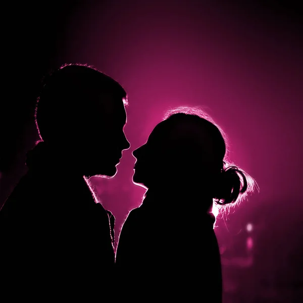 Two lovers in backlight looking each other on date — Stock Photo, Image