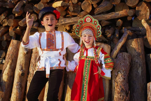 Two Russian kids in russian folk costume boy and girl dancing together and emotionally smiling — Stock Photo, Image