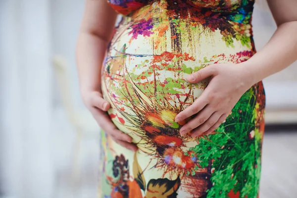 Zwangere vrouwen haar buik knuffelen — Stockfoto