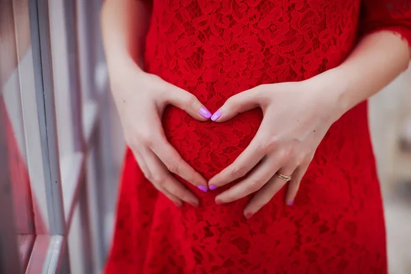 Gravid mamma gör hjärtat gest på hennes mage — Stockfoto