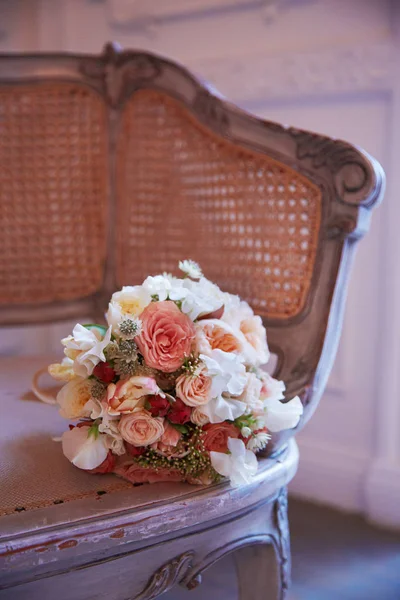 Kytice nevěsty klade na starožitné křeslo — Stock fotografie