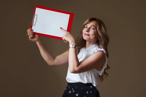 Beautiful middle age woman with empty clipboard with blank space — Stock Photo, Image