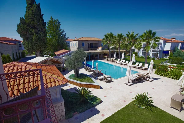 Uitzicht op ontspannende zwembad in klein boetiekhotel met palmen en tuin — Stockfoto