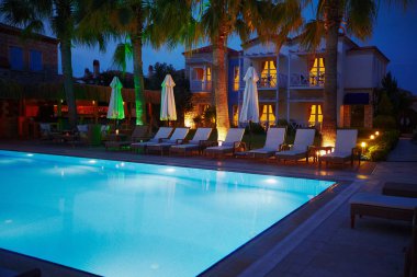 Küçük otel aydınlatma ile rahatlatıcı havuzu gece görünümü
