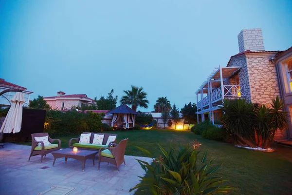 Vista nocturna de la acogedora piscina del pequeño hotel boutique mediterráneo con chaise-longue, relajante —  Fotos de Stock