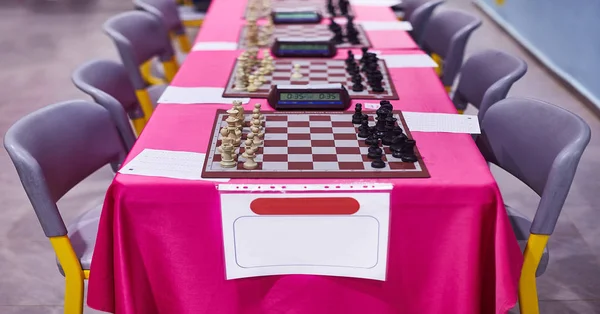 Chess tournament tables with chess timers and blank note papers