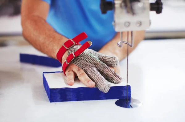 Tkanina řezací stroj a masters ruce v kovové rukavici — Stock fotografie