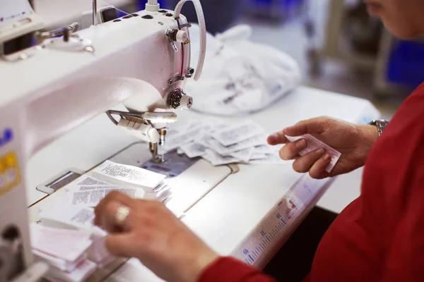 Dělník v továrně na šití v a značka značky vyráběné tkaniny. — Stock fotografie