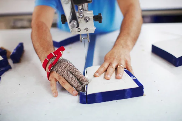 Tkanina řezací stroj a masters ruce v kovové rukavici — Stock fotografie