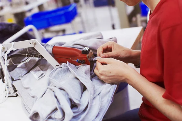 Dokončovací práce na továrnu na sukno - další vlákna řezání zastřihovač stroj v ruce pracovníka — Stock fotografie