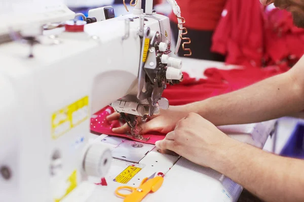 Textilní továrních dělníků ruce šití látky na profesionální šicí stroj — Stock fotografie