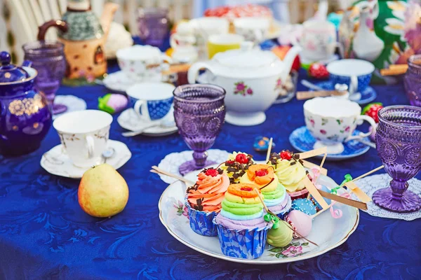 茶党与蛋糕和不同的五颜六色的杯子 — 图库照片