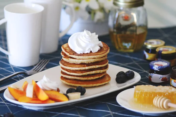 Breakfast pancakes served with honey and fruits — Stock Photo, Image