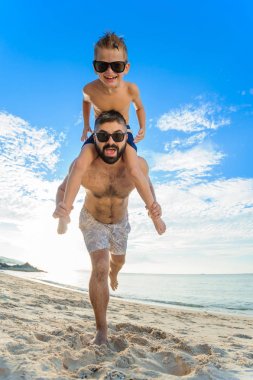 Babamın omuzlarında oturan sekiz yaşında çocuk. İkimiz de Yüzme