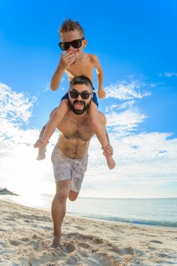 Babamın omuzlarında oturan sekiz yaşında çocuk. İkimiz de Yüzme