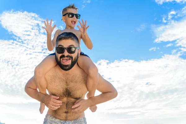 Niño de ocho años sentado sobre los hombros de papá. Tanto en la natación — Foto de Stock