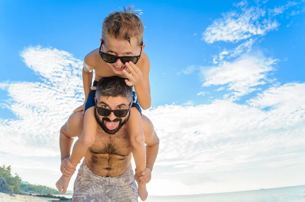 Niño de ocho años sentado sobre los hombros de papá. Tanto en la natación — Foto de Stock