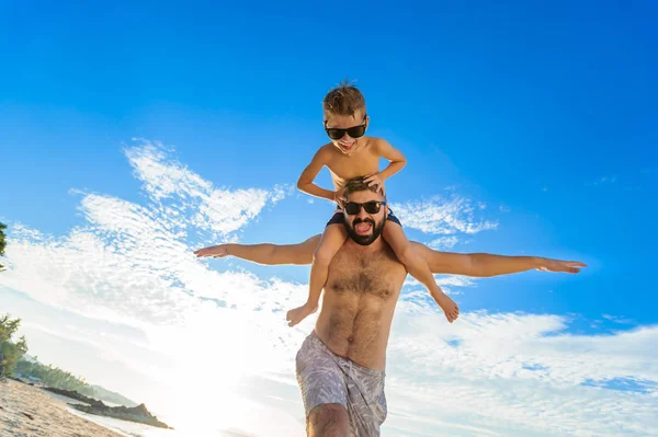 Niño de ocho años sentado sobre los hombros de papá. Tanto en la natación — Foto de Stock