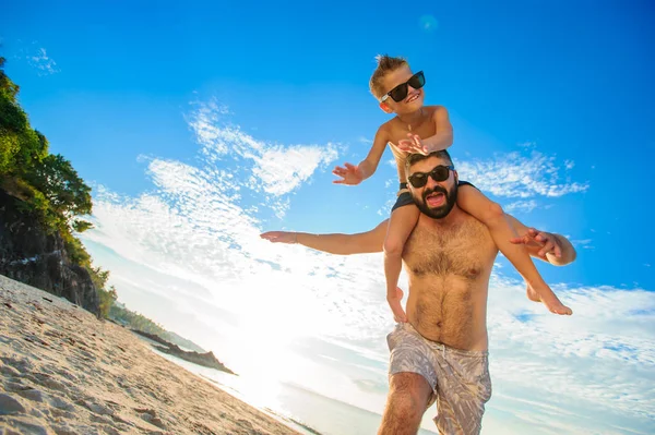 Niño de ocho años sentado sobre los hombros de papá. Tanto en la natación — Foto de Stock