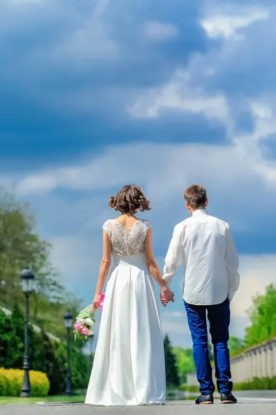年轻、 英俊的新婚夫妇在公园里散步 — 图库照片
