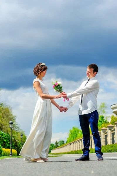 年轻、 英俊的新婚夫妇在公园里散步： 送花 — 图库照片
