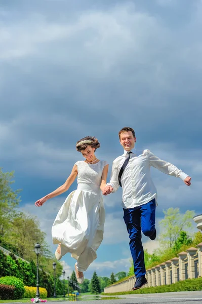 年轻、 英俊的新婚夫妇在公园里散步。跳进医管局 — 图库照片