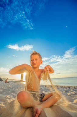 Yakışıklı sekiz yıl çocuk sahilde gerçekleştirir akrobatik çizimler bir