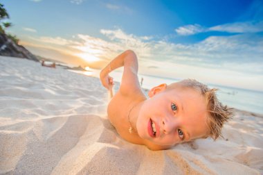 Yakışıklı sekiz yıl çocuk sahilde gerçekleştirir akrobatik çizimler bir