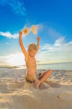 Yakışıklı sekiz yıl çocuk sahilde gerçekleştirir akrobatik çizimler bir