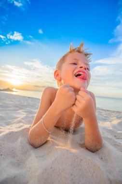 Yakışıklı sekiz yıl çocuk sahilde gerçekleştirir akrobatik çizimler bir