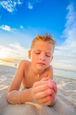 Yakışıklı sekiz yıl çocuk sahilde gerçekleştirir akrobatik çizimler bir