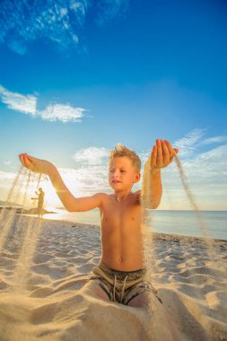 Yakışıklı sekiz yıl çocuk sahilde gerçekleştirir akrobatik çizimler bir