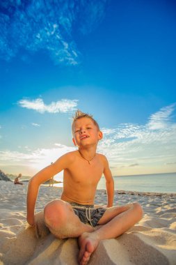Yakışıklı sekiz yıl çocuk sahilde gerçekleştirir akrobatik çizimler bir