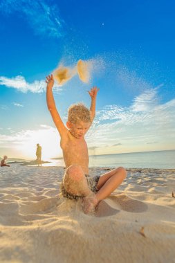Yakışıklı sekiz yıl çocuk sahilde gerçekleştirir akrobatik çizimler bir