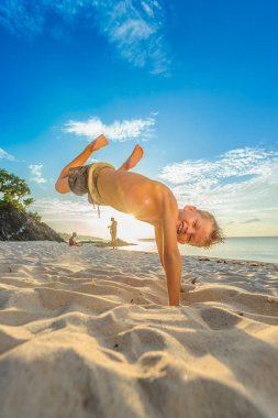Yakışıklı sekiz yıl çocuk sahilde gerçekleştirir akrobatik çizimler bir