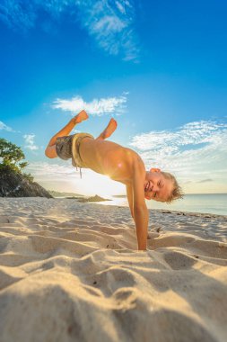 Yakışıklı sekiz yıl çocuk sahilde gerçekleştirir akrobatik çizimler bir