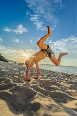 Yakışıklı sekiz yıl çocuk sahilde gerçekleştirir akrobatik çizimler bir