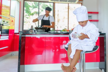 Tatlı Tay çocuğu şefin şapka ve yüksek c üzerinde oturan tunik